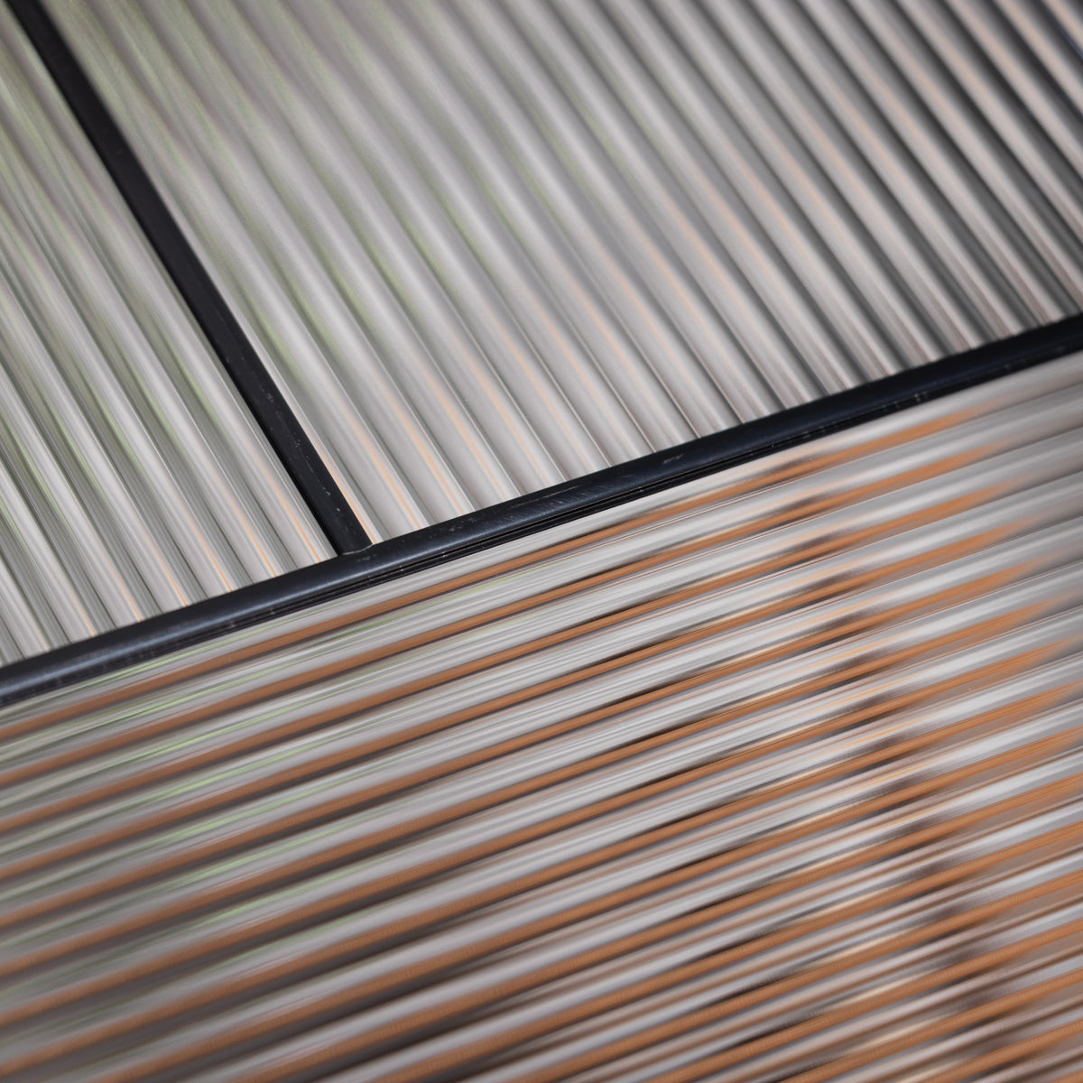 Close-up of Rill textured privacy glass with fine reeded lines and black caming