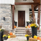 Contemporary 14 fiberglass entry door on a stone and white board-and-batten home with autumn decor