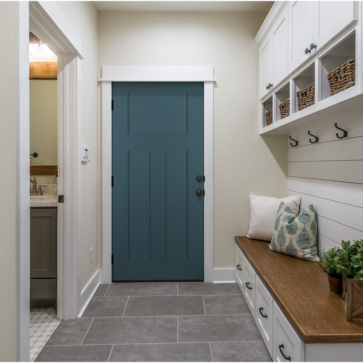 Teal 3 panel Shaker fiberglass door in a mudroom with storage cubbies